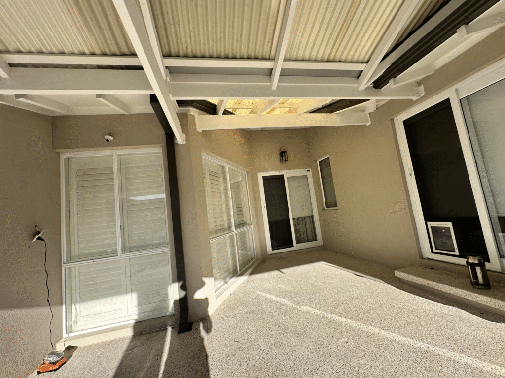 Professional painter applying primer to new plaster walls in Perth.